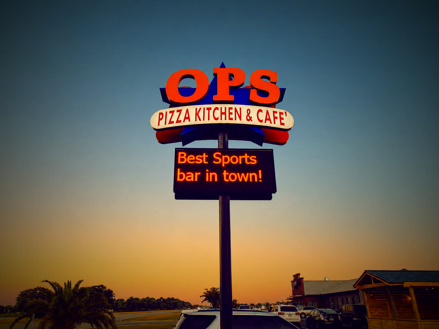 The OPS Pizza Kitchen & Café sign at dusk on Boone Avenue in Kingsland